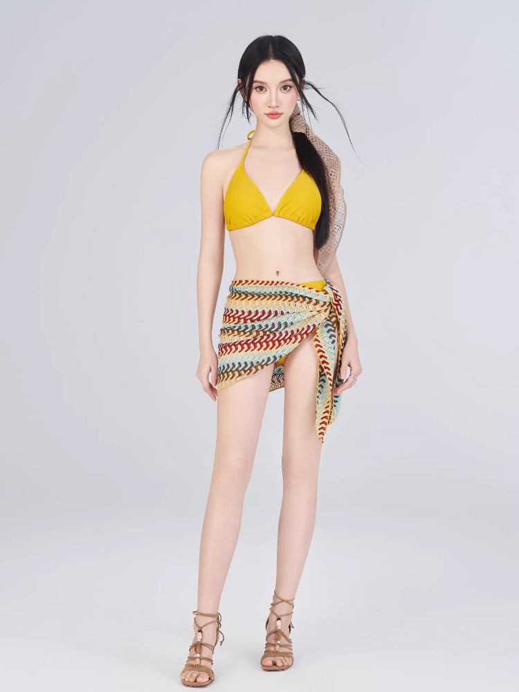 Woman wearing a yellow bikini with a crocheted wrap skirt