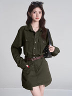 Woman wearing a green button-down shirt and matching mini skirt with a brown belt and black handbag