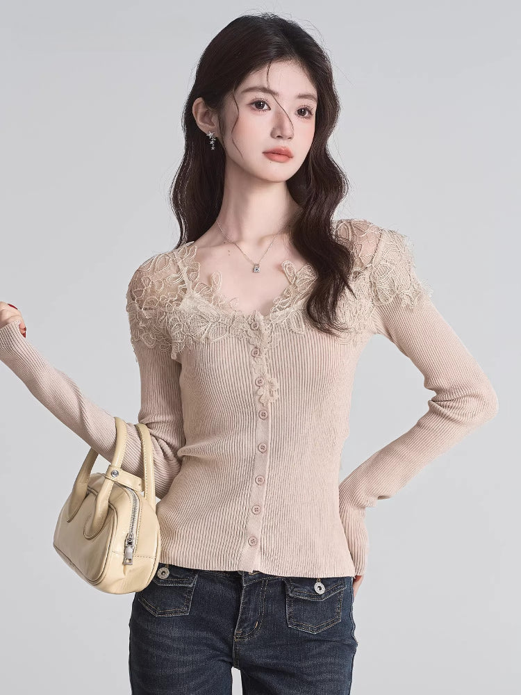 Woman holding a beige handbag, wearing a beige ribbed knit cardigan with lace trim and a v-neck, paired with dark wash jeans.