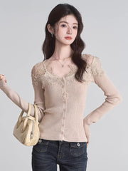Woman holding a beige handbag, wearing a beige ribbed knit cardigan with lace trim and a v-neck, paired with dark wash jeans.