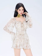 Front view of a woman posing in a floral print off-the-shoulder dress with a green floral choker.