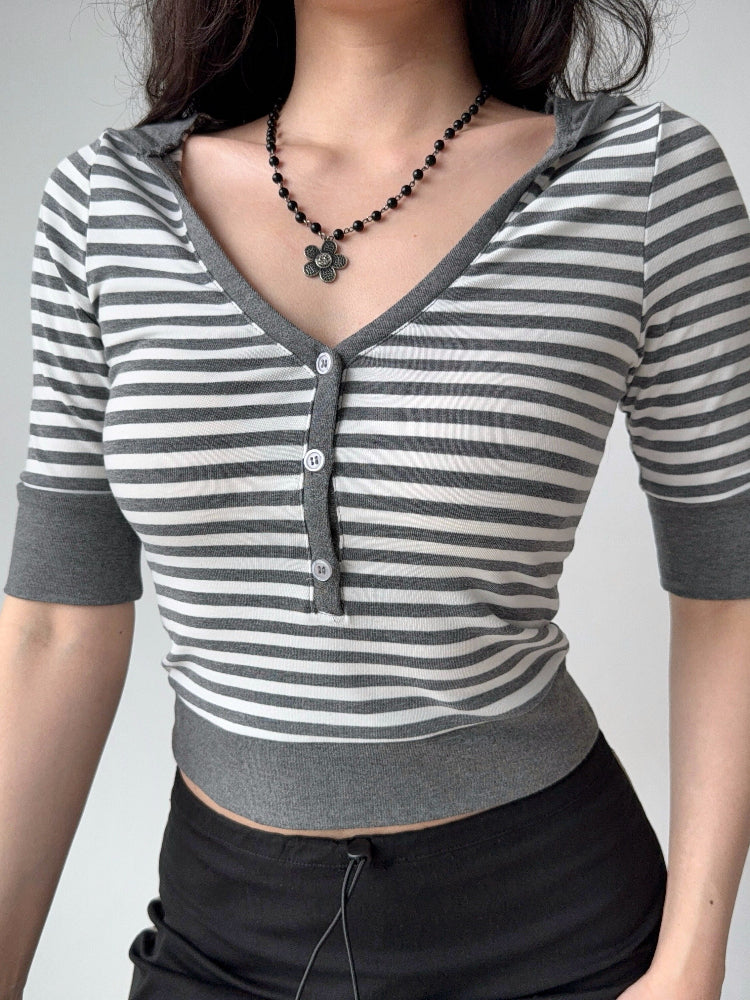 Detail shot of the neckline and buttons on a grey and white striped cropped top.
