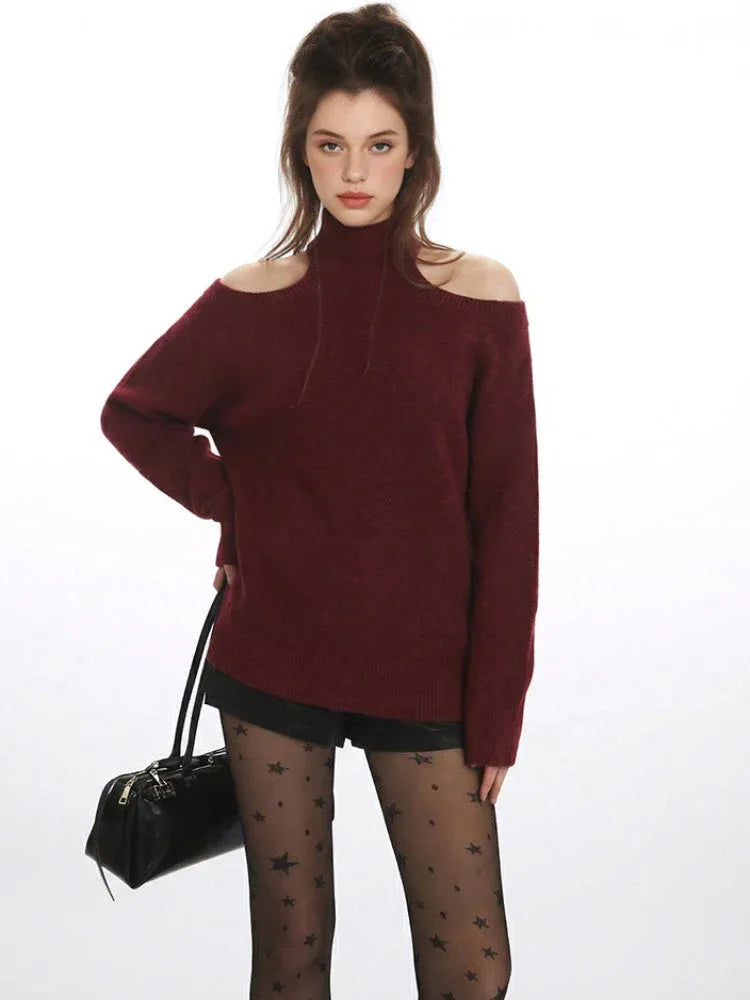Close-up of a model in a maroon open-shoulder sweater with a mock neckline.