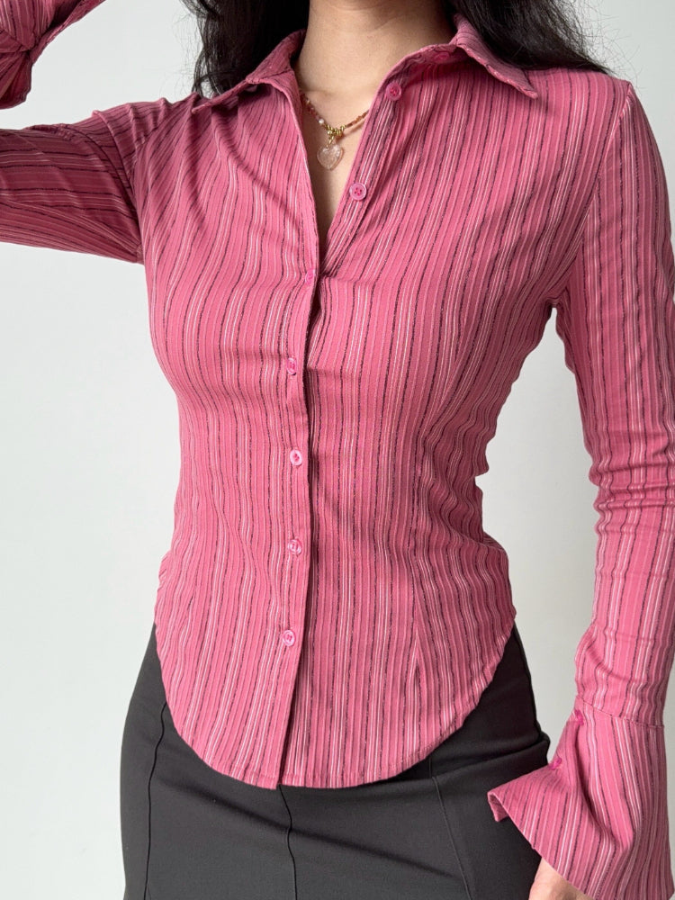 Close-up of a woman in a pink striped button-up shirt.