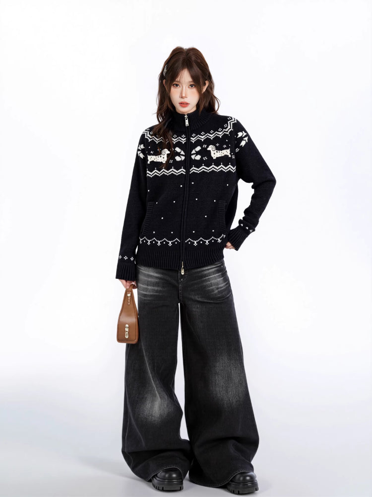 Woman holding a brown handbag and wearing a black zip-up knit sweater with a white fair isle dog pattern.