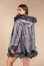 Back view of a woman wearing a grey faux fur coat