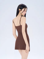 Back view of a woman wearing a brown ruched mini dress.
