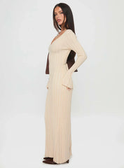 Side profile of a woman showcasing a cream ribbed knit maxi dress with a flattering silhouette and long sleeves.