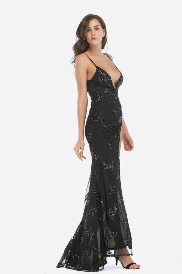 Woman wearing a black sequined formal gown with a high slit and deep V-neck, side view