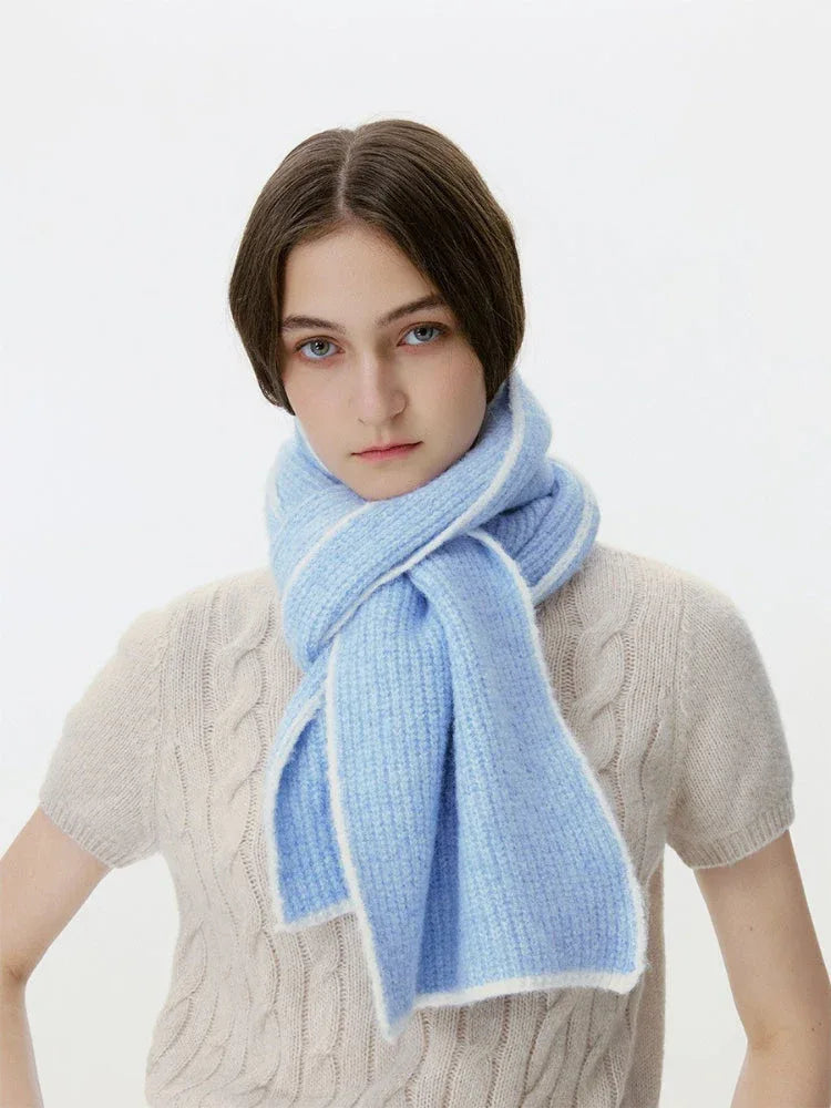 Woman wearing a light blue ribbed knit scarf with white trim
