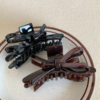 black and brown glossy bow claw clips on a plate