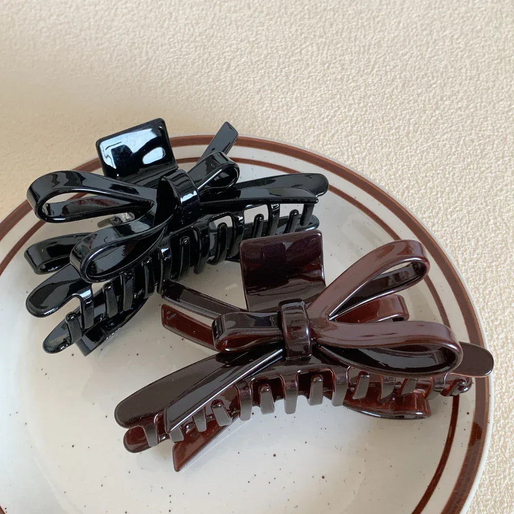 black and brown glossy bow claw clips on a plate