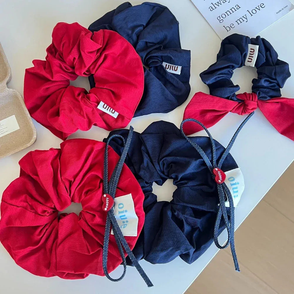 Collection of red and navy scrunchies with bow and heart charm details