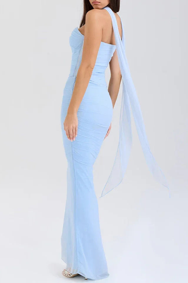 Woman wearing a light blue strapless ruched mesh gown with a long flowing scarf detail from the back, showcasing the mermaid hemline. Main image