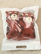 Two red panda character crew socks packaged in a clear bag