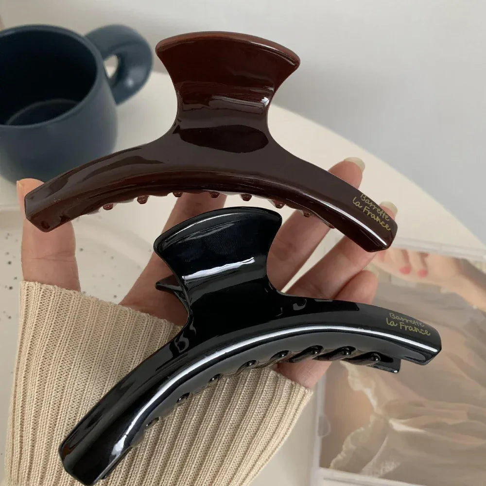 hand holding a brown and black hair claw clip
