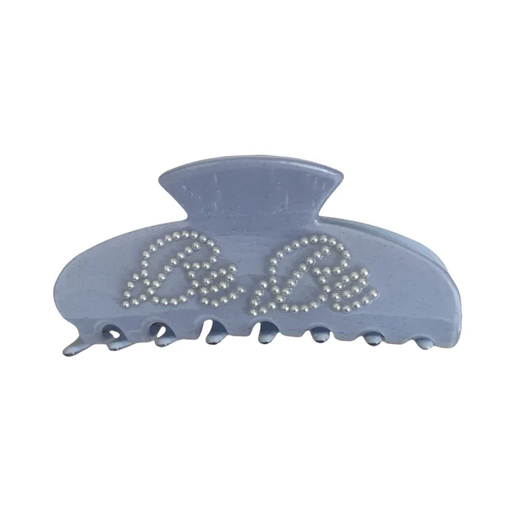 A single light blue claw clip with "Be Be" lettering made of pearl-like studs.