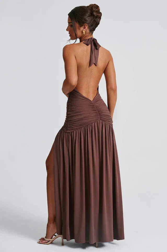back view of a woman wearing a brown halter maxi dress with an open back and ruched detailing