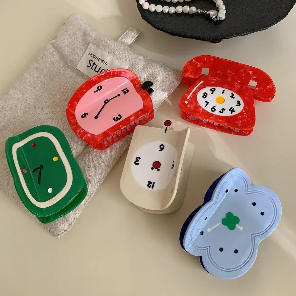 Various novelty hair clips including clocks, a telephone, and a flower