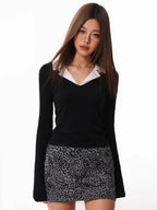 Model posing in a black long-sleeved top with a white contrast collar and a leopard print skirt.
