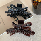 black and brown glossy bow claw clips on a book