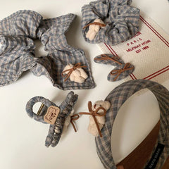 selection of grey plaid hair accessories, including scrunchies, headbands, clips, and barrettes, decorated with teddy bear motifs
