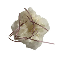 Close-up of an oversized ivory scrunchie with delicate pink ribbon ties.
