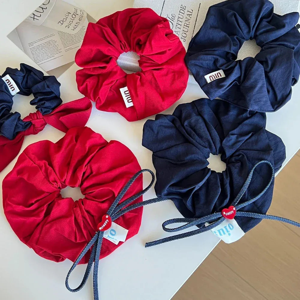 Top-down view of red and navy scrunchies with various decorative elements