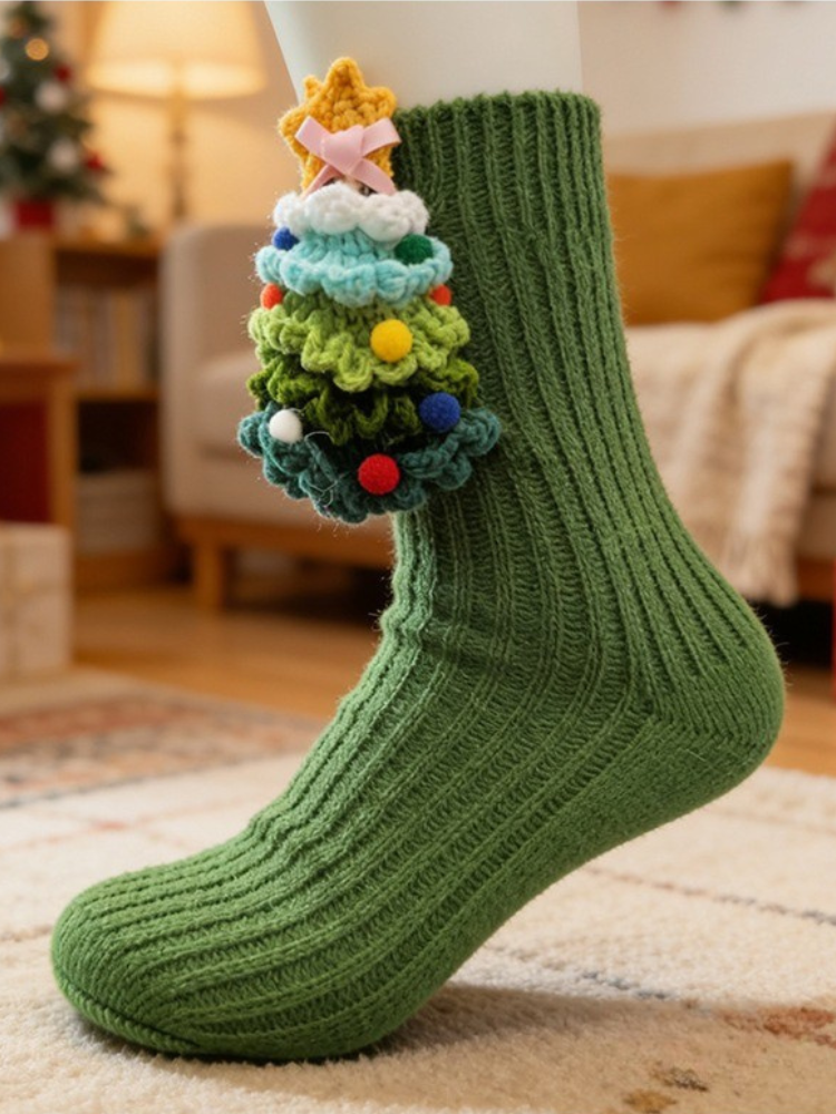 Green ribbed knit crew socks with a crocheted Christmas tree embellishment on the side.
