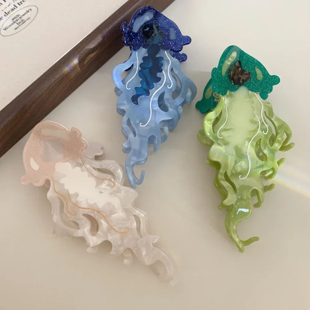 Three jellyfish hair clips in blue, green, and pink, arranged closely