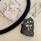 White and black marbled cat hair clips with pink bows