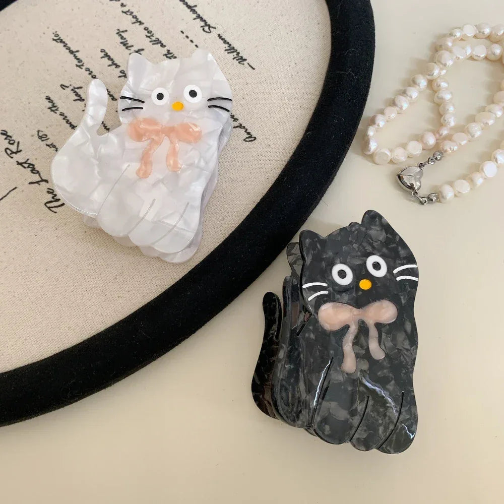 White and black marbled cat hair clips with pink bows