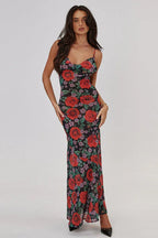 Woman wearing a long floral print dress with spaghetti straps and a cowl neckline, front view.