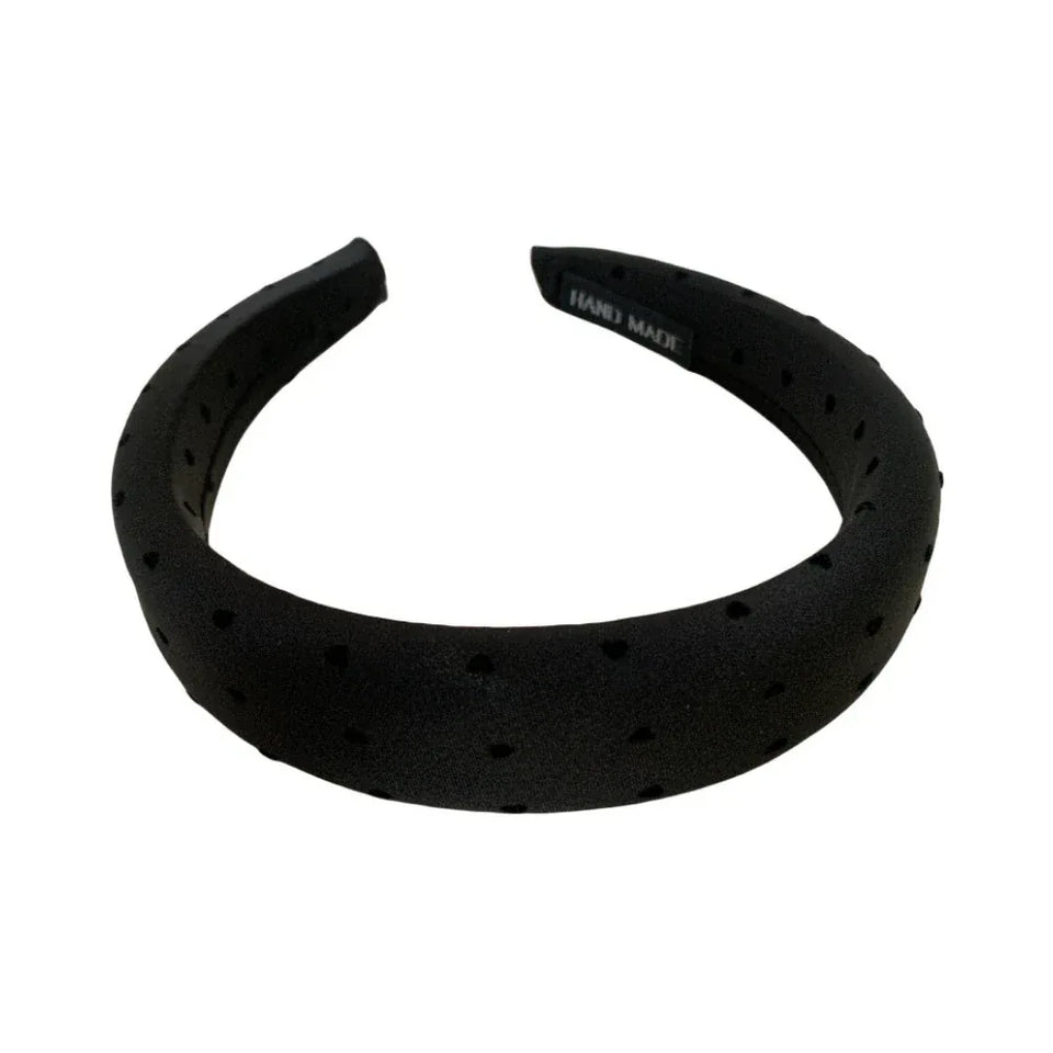 A black puffy headband with a scattered heart print. Main image