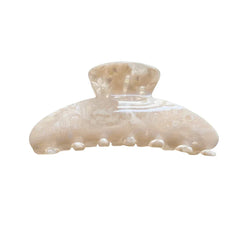 Close-up of a cream-colored marbled acetate claw clip against a white background.