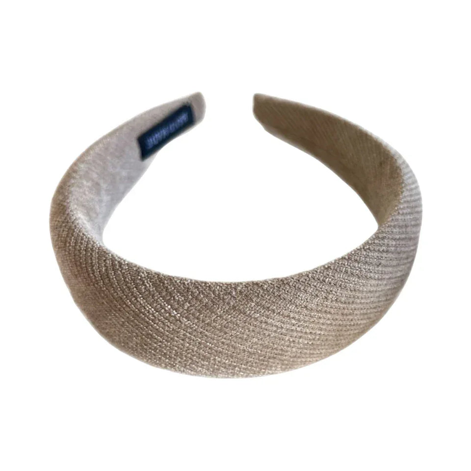 A single padded headband in a neutral beige color with a textured fabric finish, shown on a white background. Main image