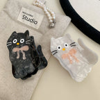 White and black marbled cat hair clips with pink bows and fabric pouch