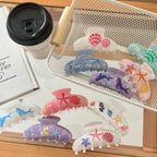 A basket filled with iridescent hair claw clips showcasing marine life patterns