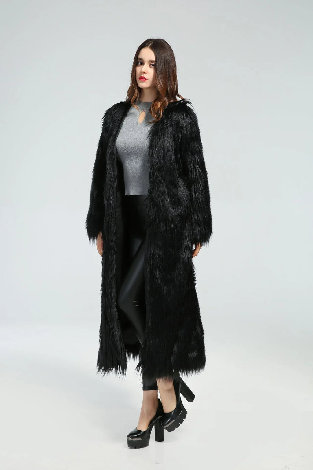 Woman standing in a long black faux fur coat, angled slightly