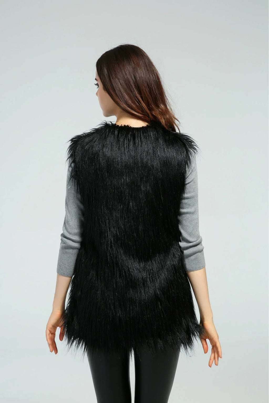 Back view of a woman in a black faux fur vest