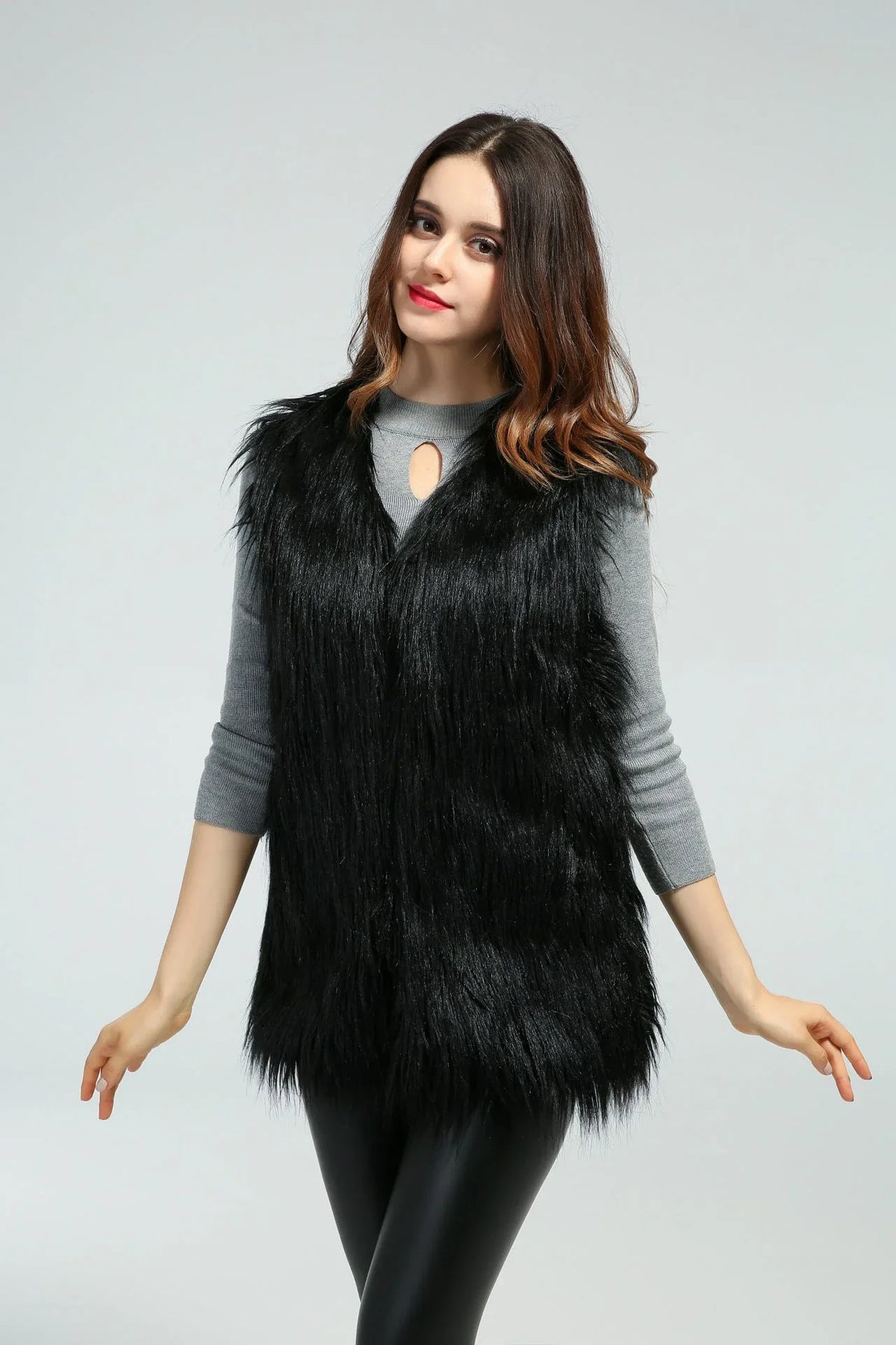 Woman posing with arms outstretched wearing a black faux fur vest