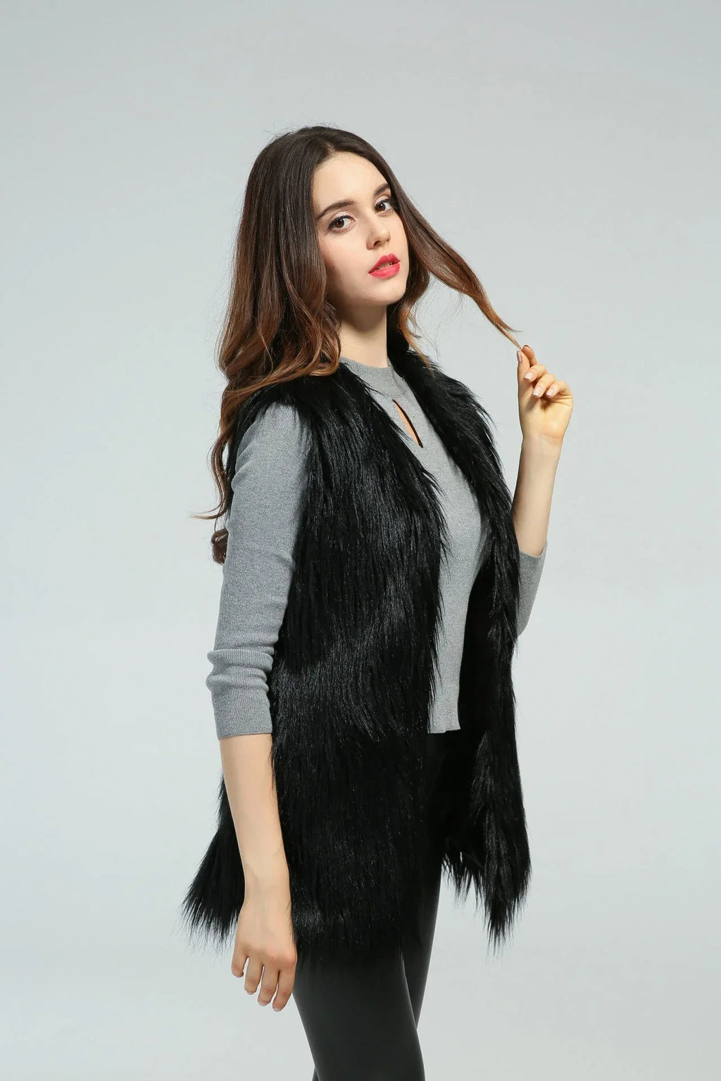 Side profile of a woman wearing a black faux fur vest