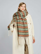 Close-up of a woman wearing a cream coat and a textured, striped scarf with fringe