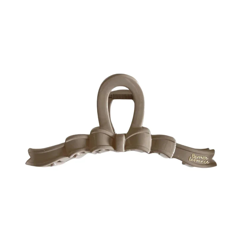 A single beige bow claw clip against a white background. Main image