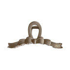 A single beige bow claw clip against a white background.