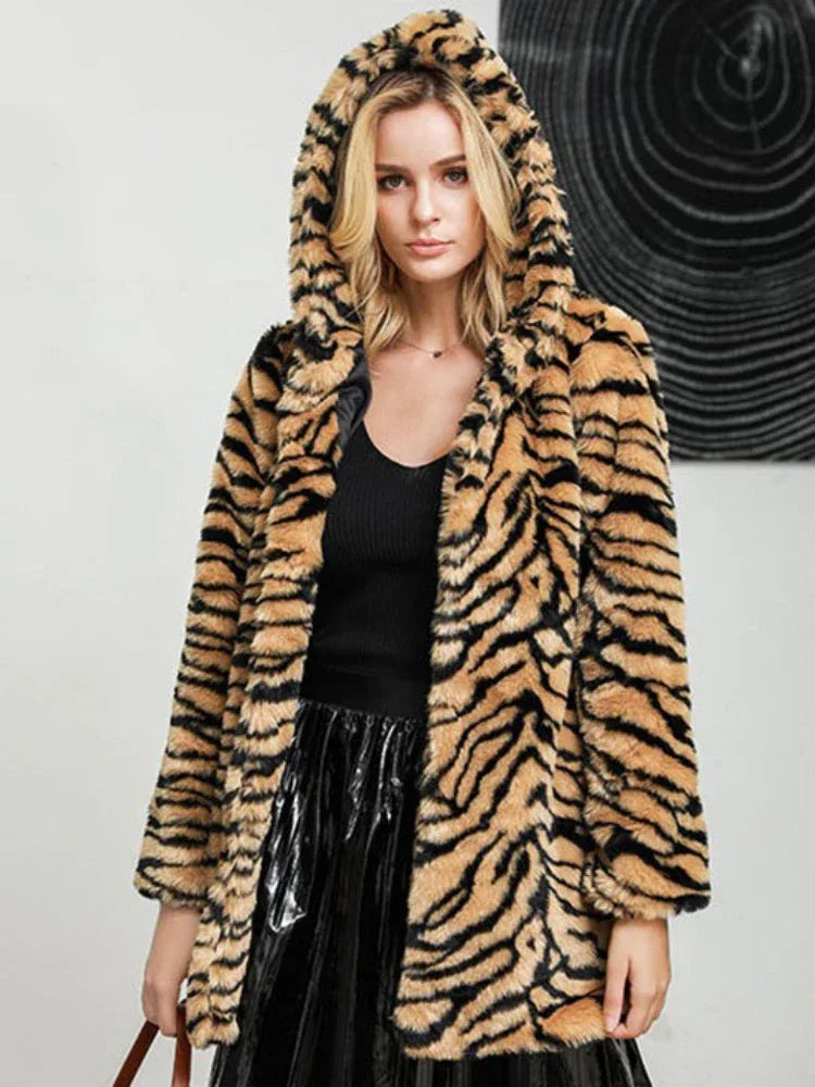 Woman wearing a hooded faux fur tiger print long coat.