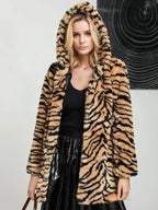 Woman wearing a hooded faux fur tiger print long coat.