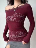 Model from the side wearing the burgundy top and a grey skirt.