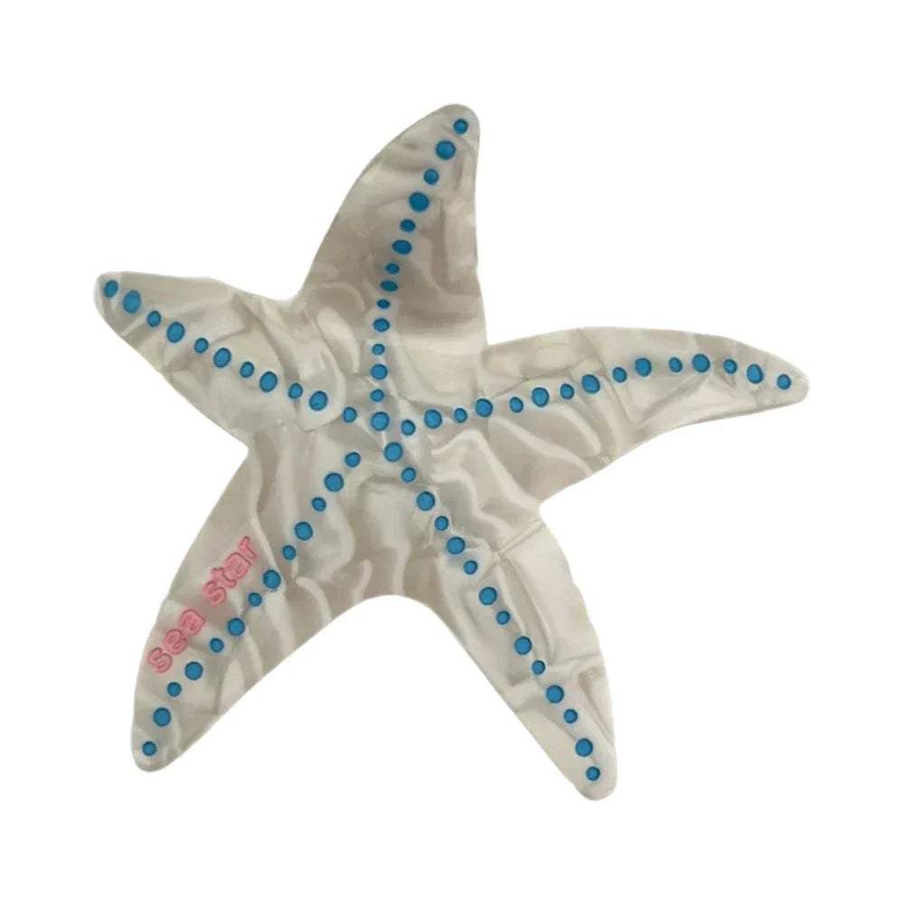 White marbled starfish hair clip with blue dots and "sea star" text