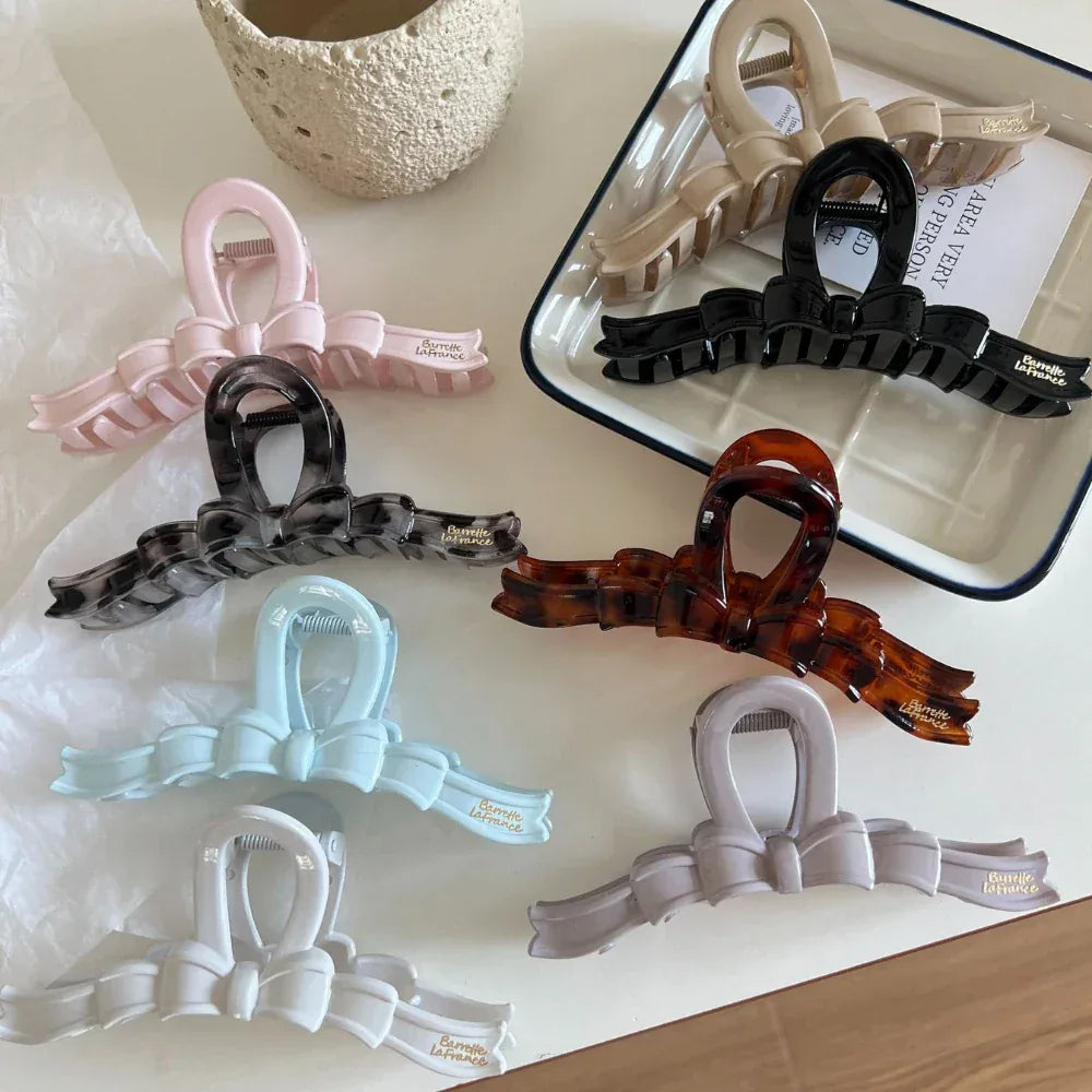 A group of bow claw clips in different colors displayed on a table.